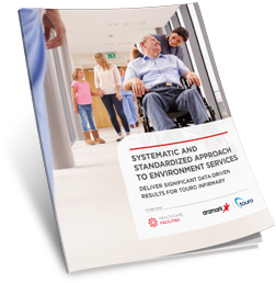A smiling nurse pushing an older man in a wheelchair.